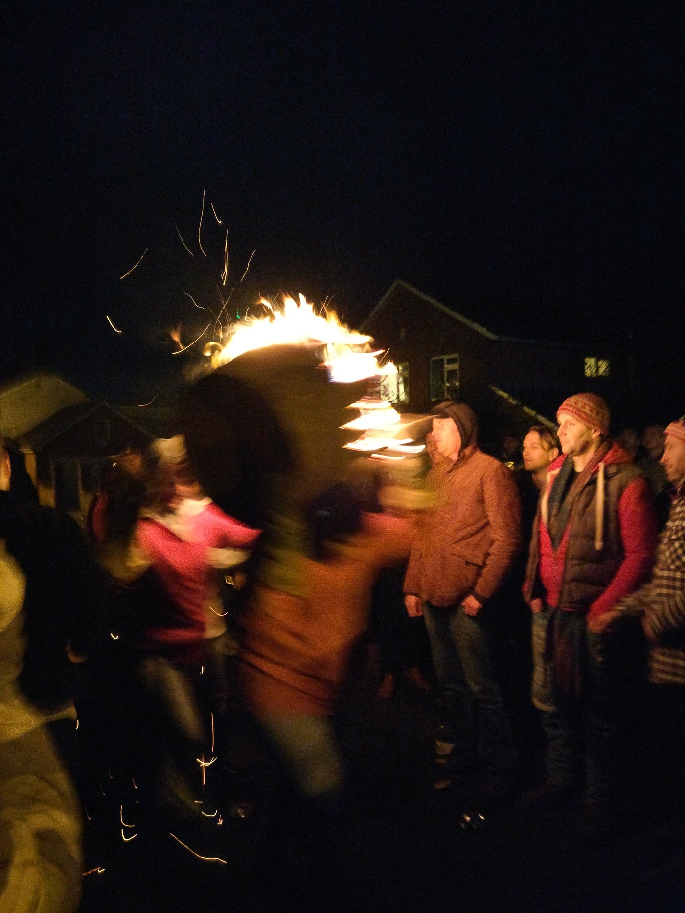 Two men run with a burning barrel in Ottery St Mary