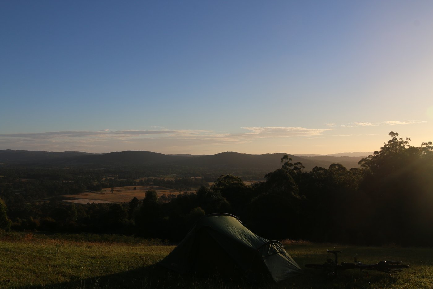 My tent, pitched on a hill looking across the valley as the sun sets. Victoria, Australia