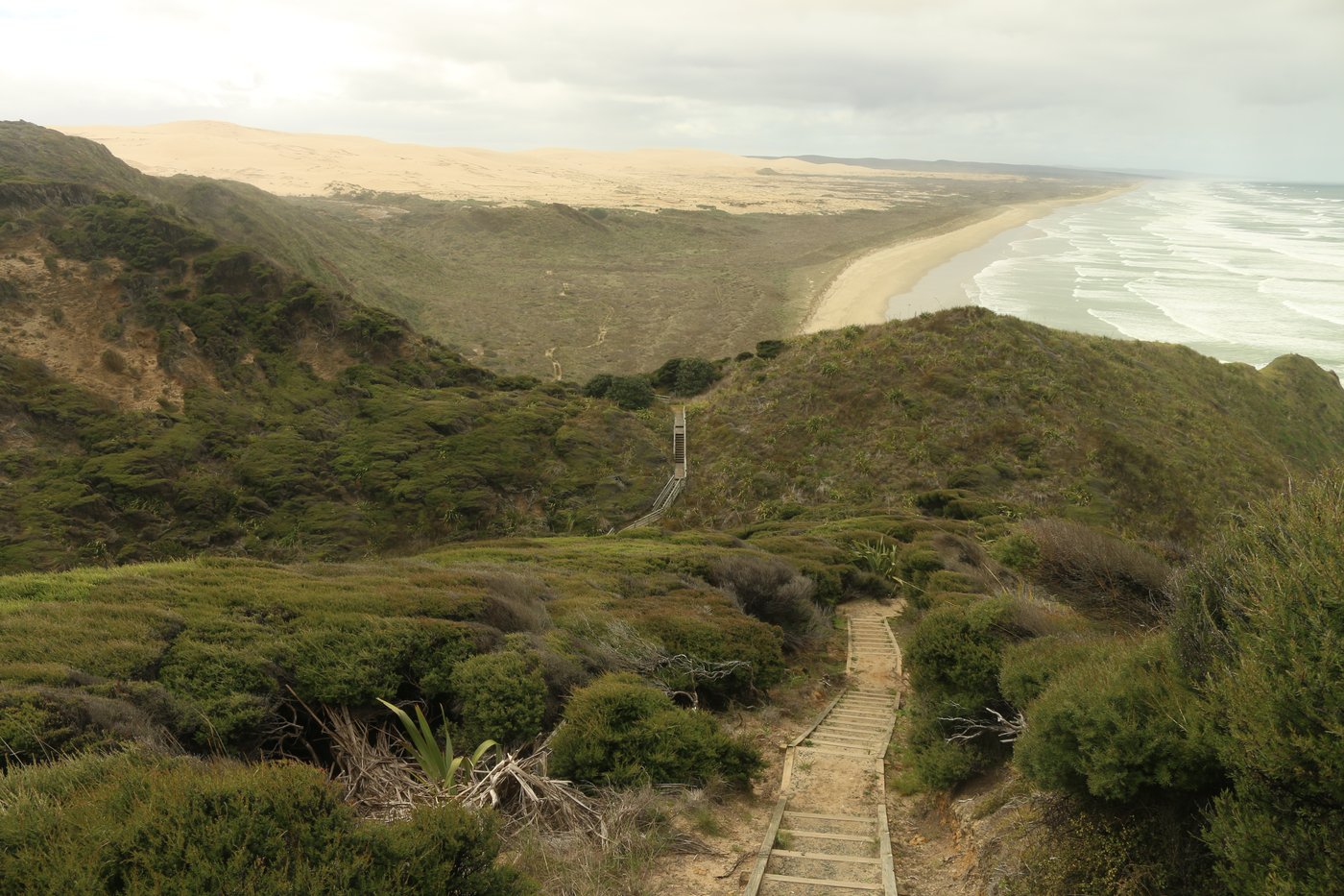 Steps descend from the headland to the beach.