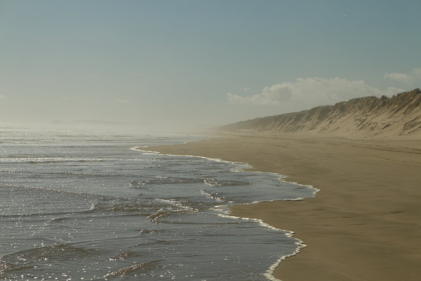 The headland disappears into the haze behind us