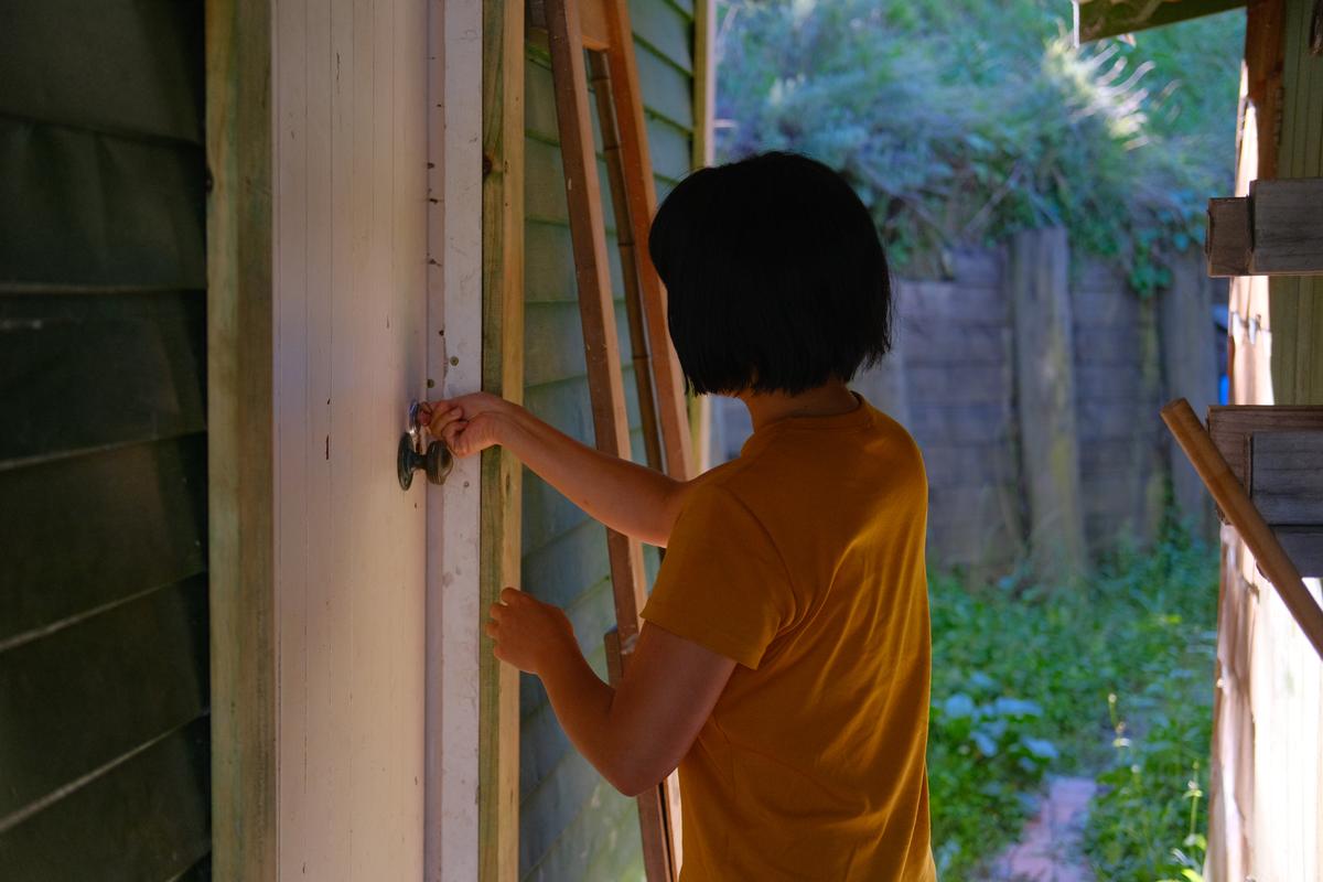 Mizuki unlocks the door to our new home – a tool shed.