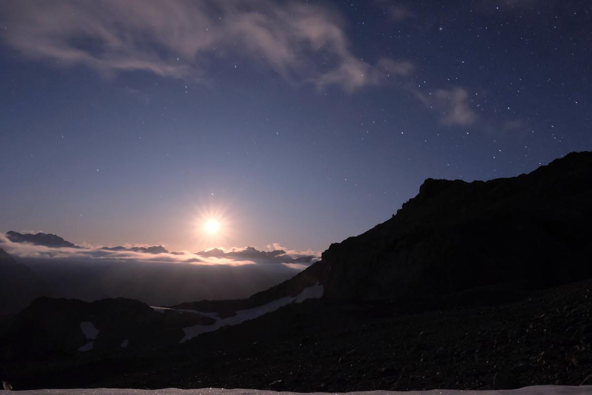 A blinding moon rise just before midnight from the top of Ball Glacier, Aoraki National Park, New Zealand
