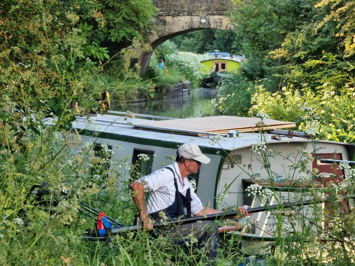 A man fishes the canal from the bank