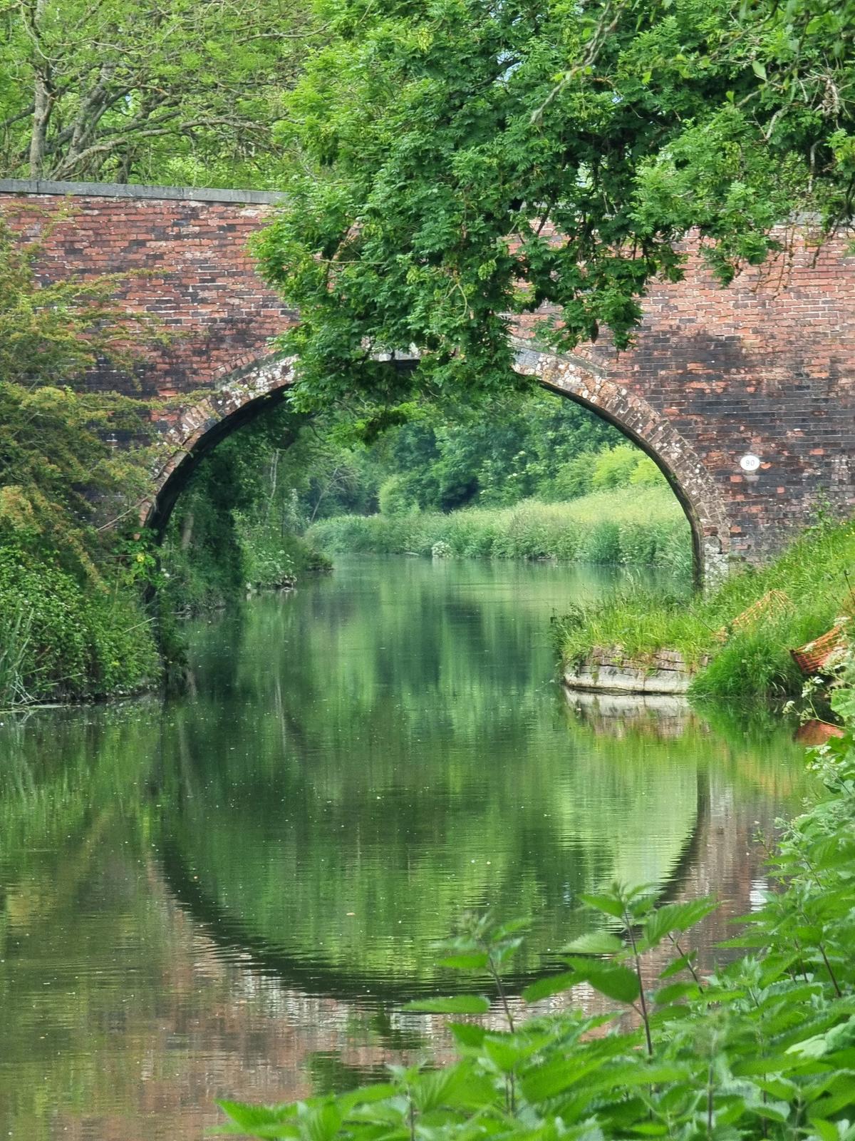 A bridge perfectly reflected in the surface of the canal