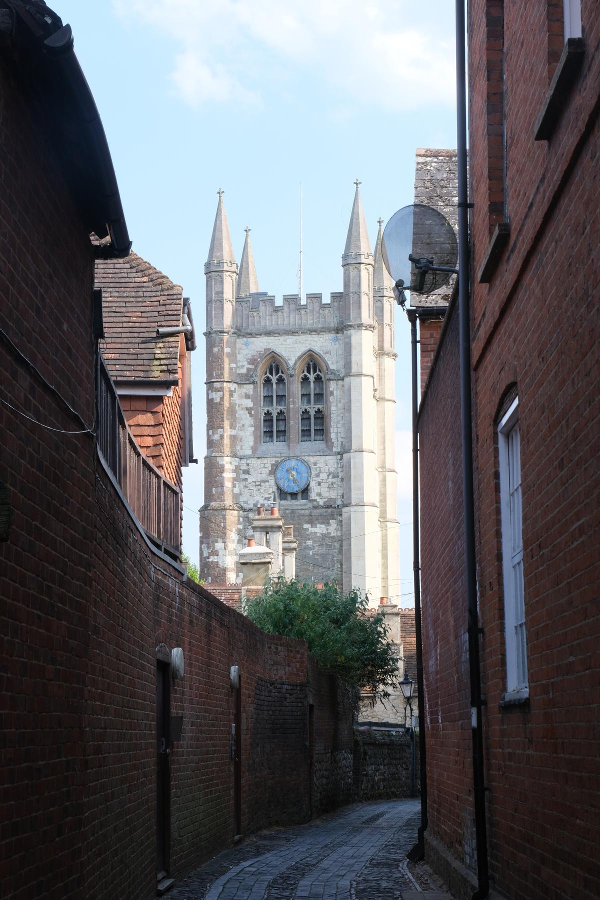 A church peeking out over an brick alleyway