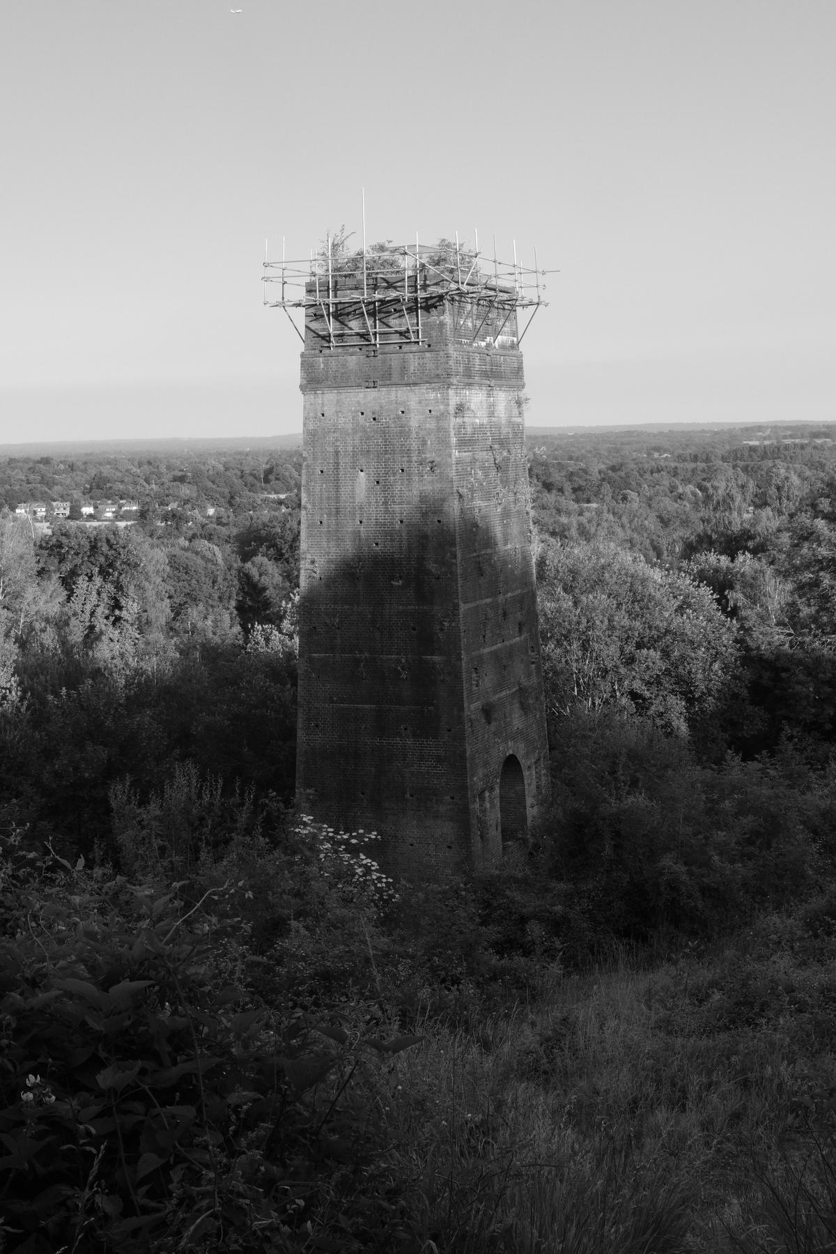 An old abandoned tower is ringed with a crown of scaffolding