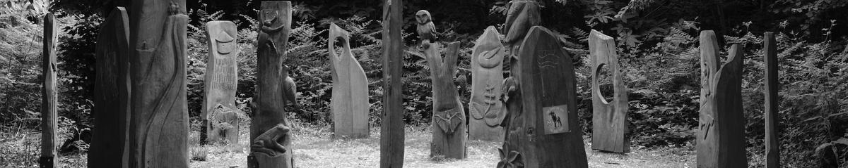 A ring of wooden carved figures in a clearing in the forest