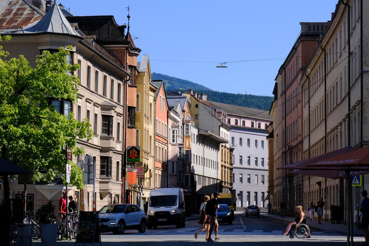 An intersection with cars and people crossing in Innsbruck, Austria