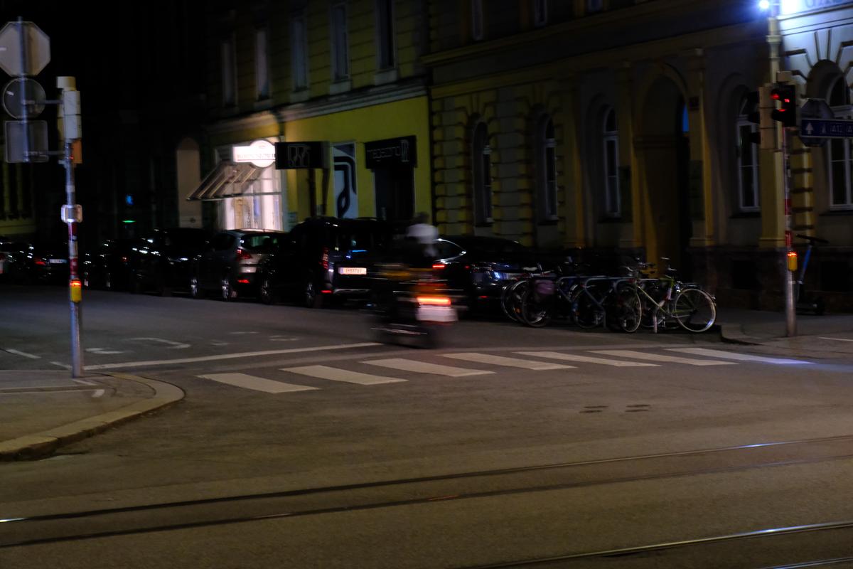 A moped speeds through an intersection in Innsbruck, Austria
