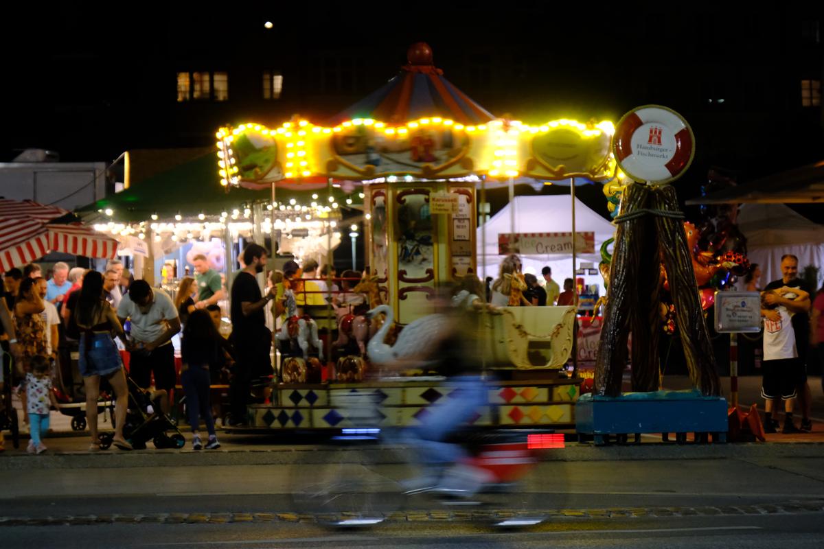 A motion blurred cyclist in front of a merry go round. Innsbruck, Austria