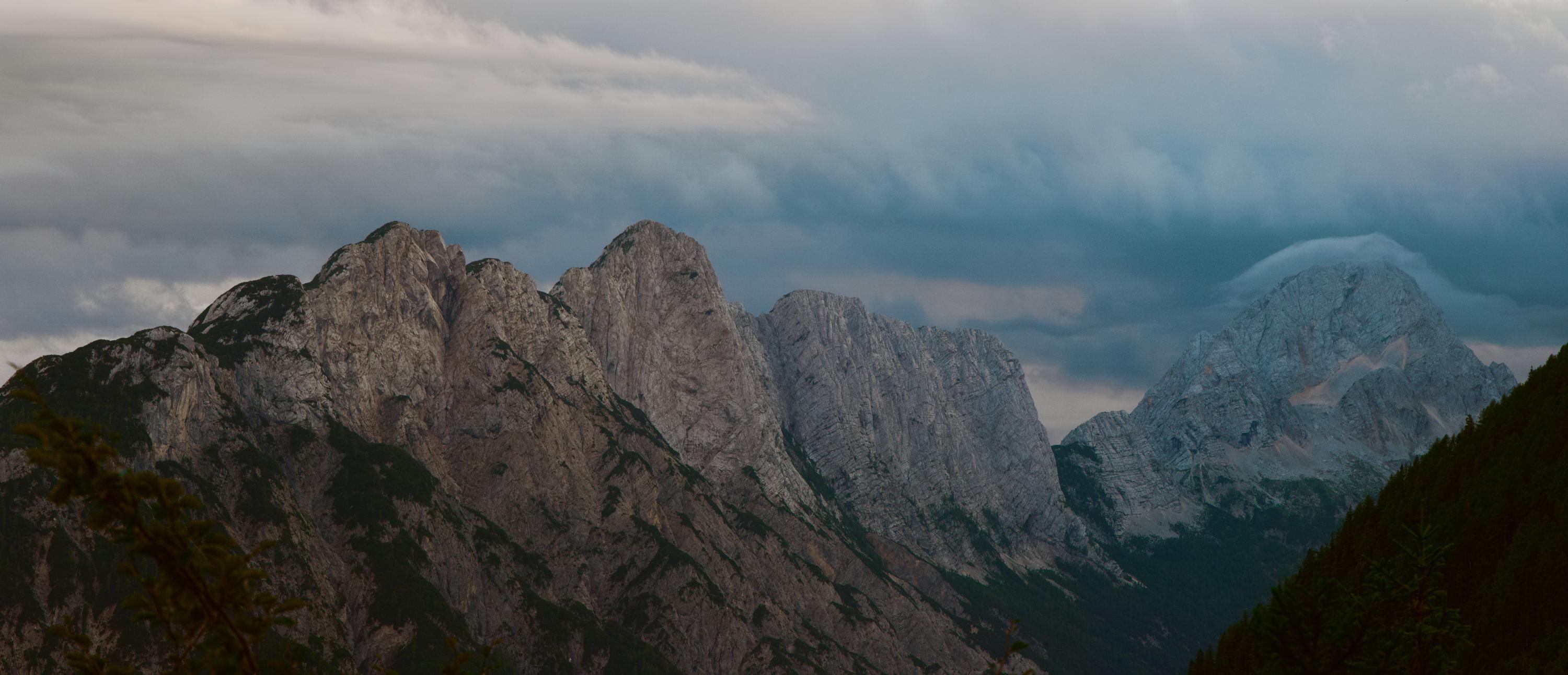 A ridgeline backed by cloud, with one cloud sitting like a cap on the right most peak, near Mount Triglav, Slovenia