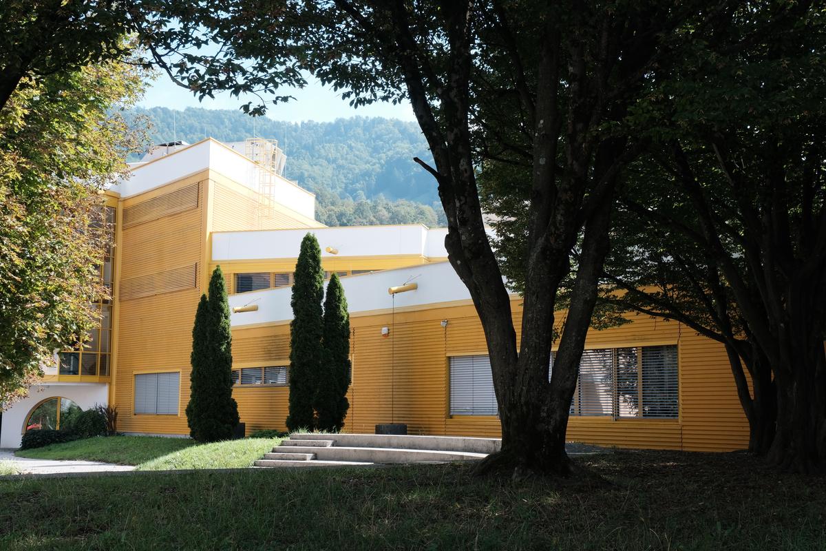 A bright yellow school made of corrugated sheet metal. Idrija, Slovenia