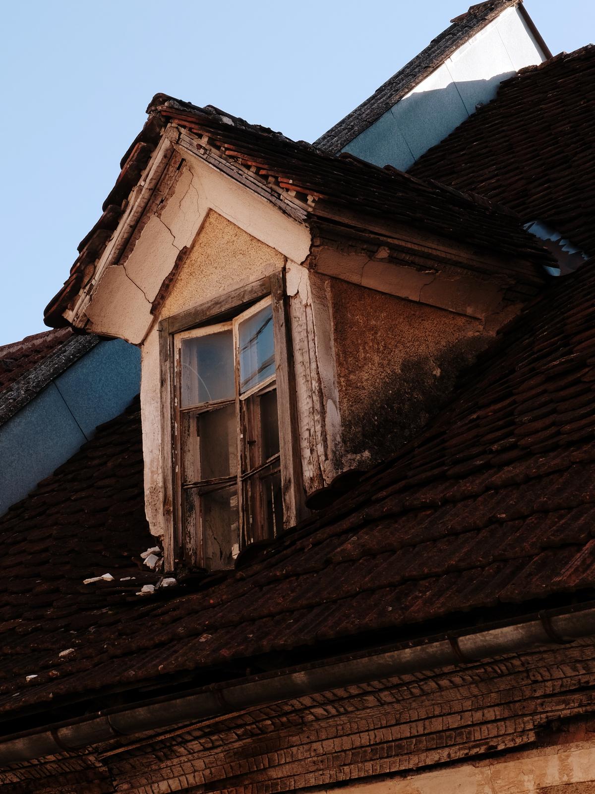 A dormer window sinks into a slowly collapsing roof. Planina, Postojna, Slovenia.