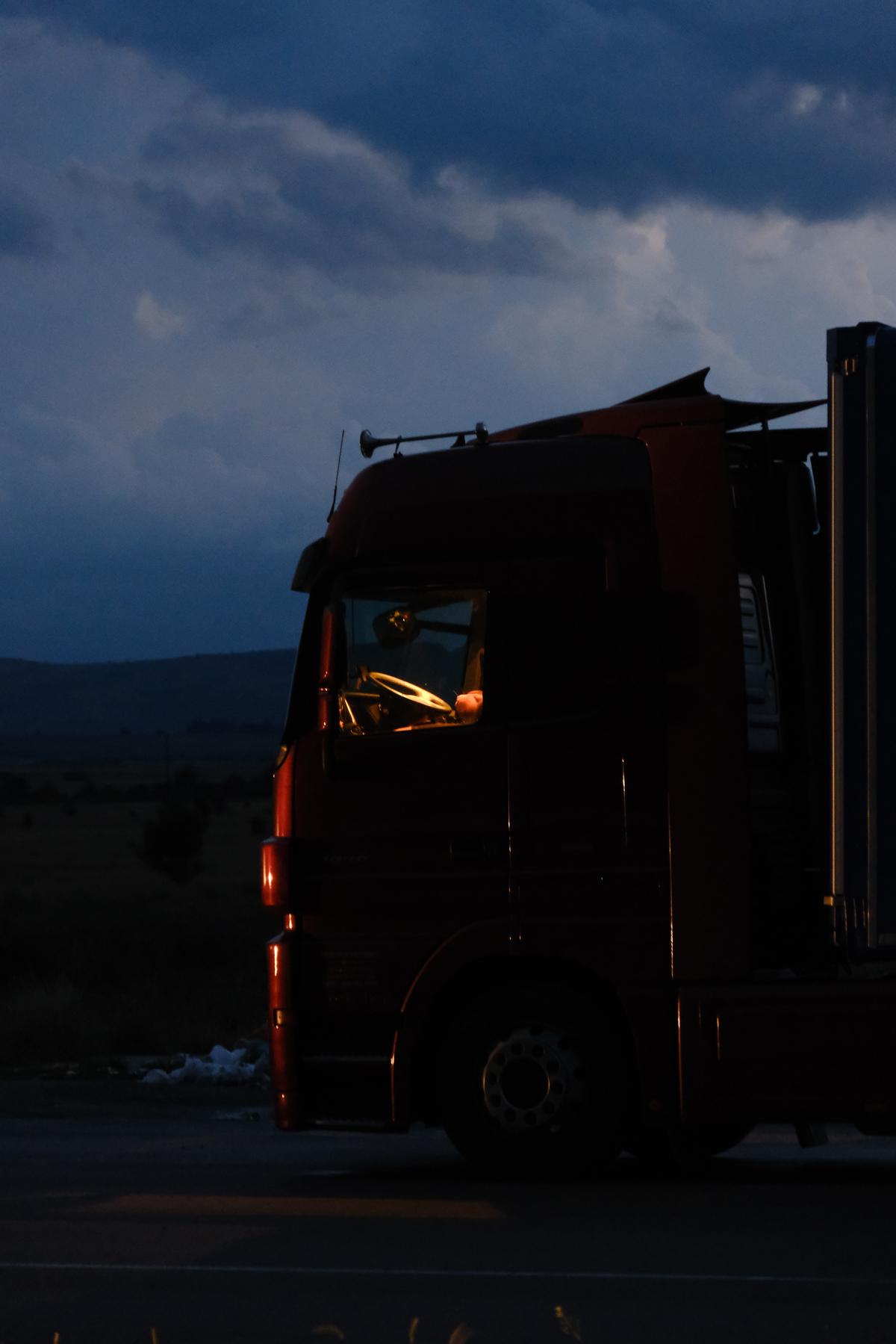 The cab of a lorry, lit by the setting sun and a warm light within, Croatia 
