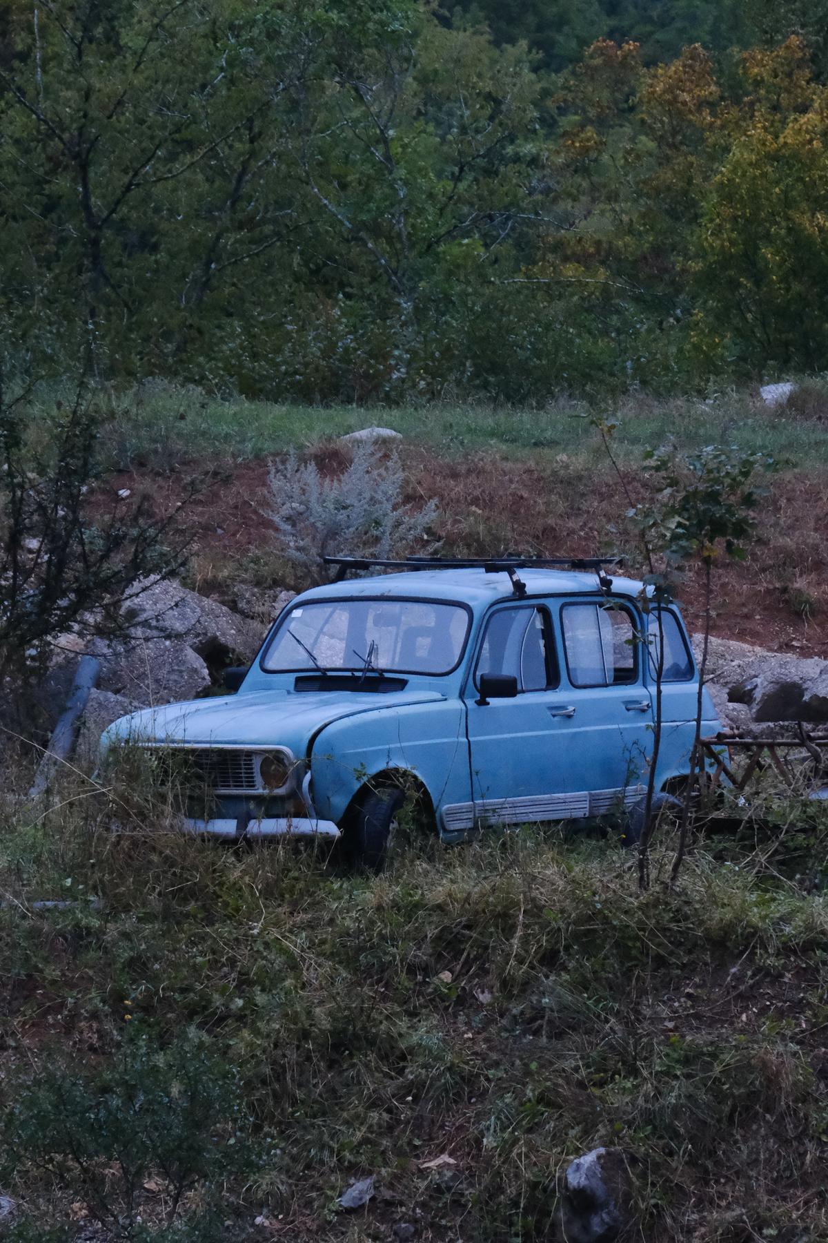 A pale blue Lada left for scrap on a hillside, Croatia