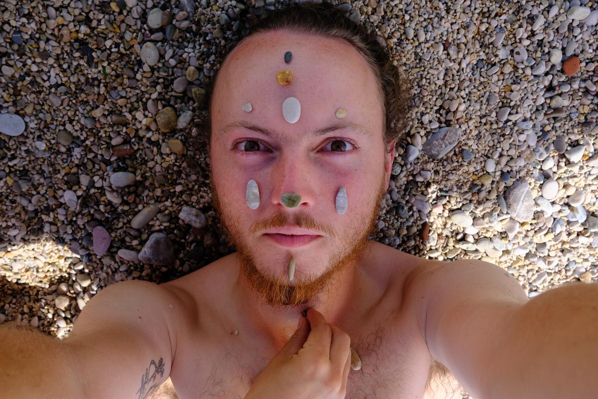 Mizuki placing pebbles on my face at the beach where we lounged for three days in Herceg Novi, Montenegro
