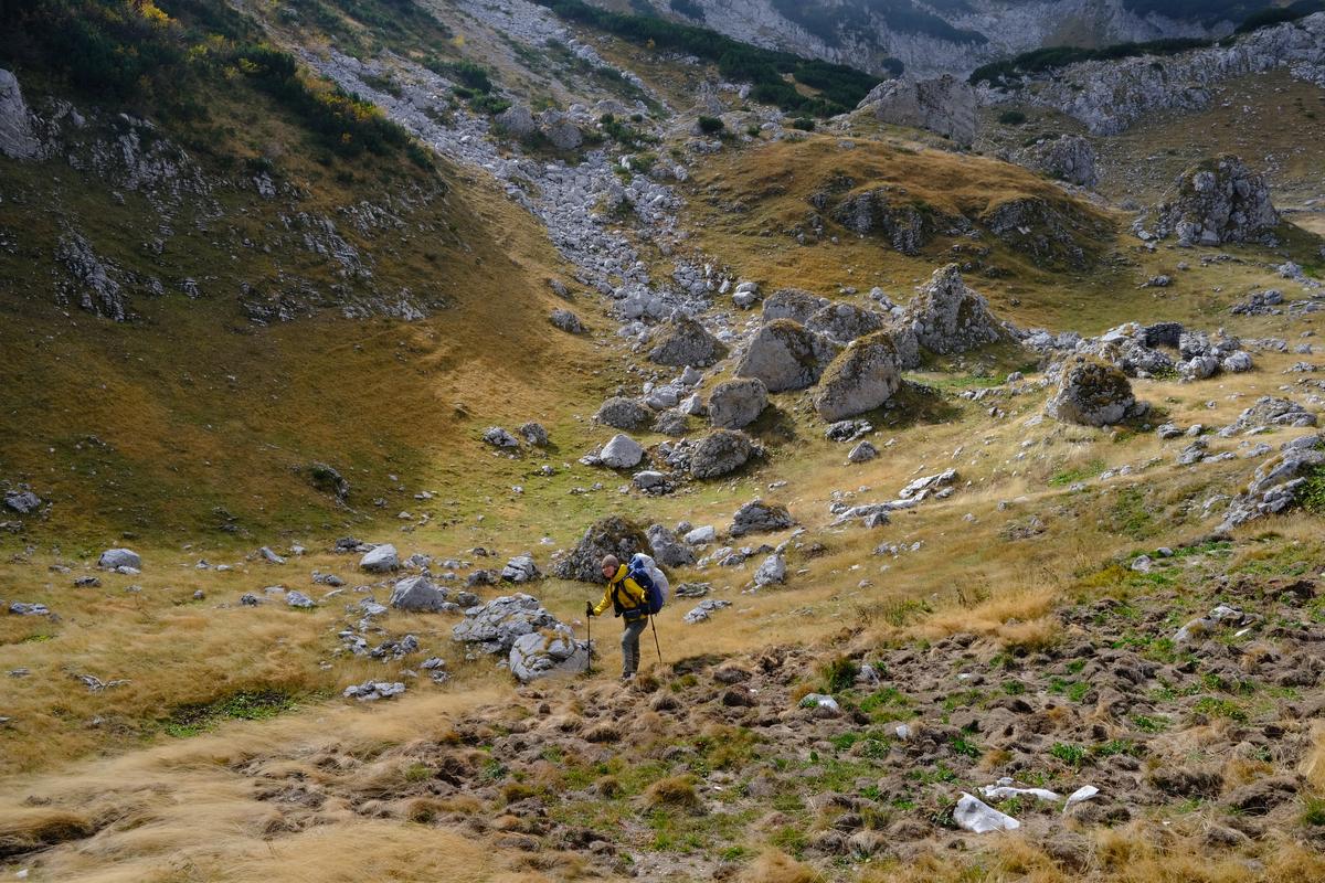 Mizuki stood in front of a boulder field after a very windy descent from Planinica, Montenegro