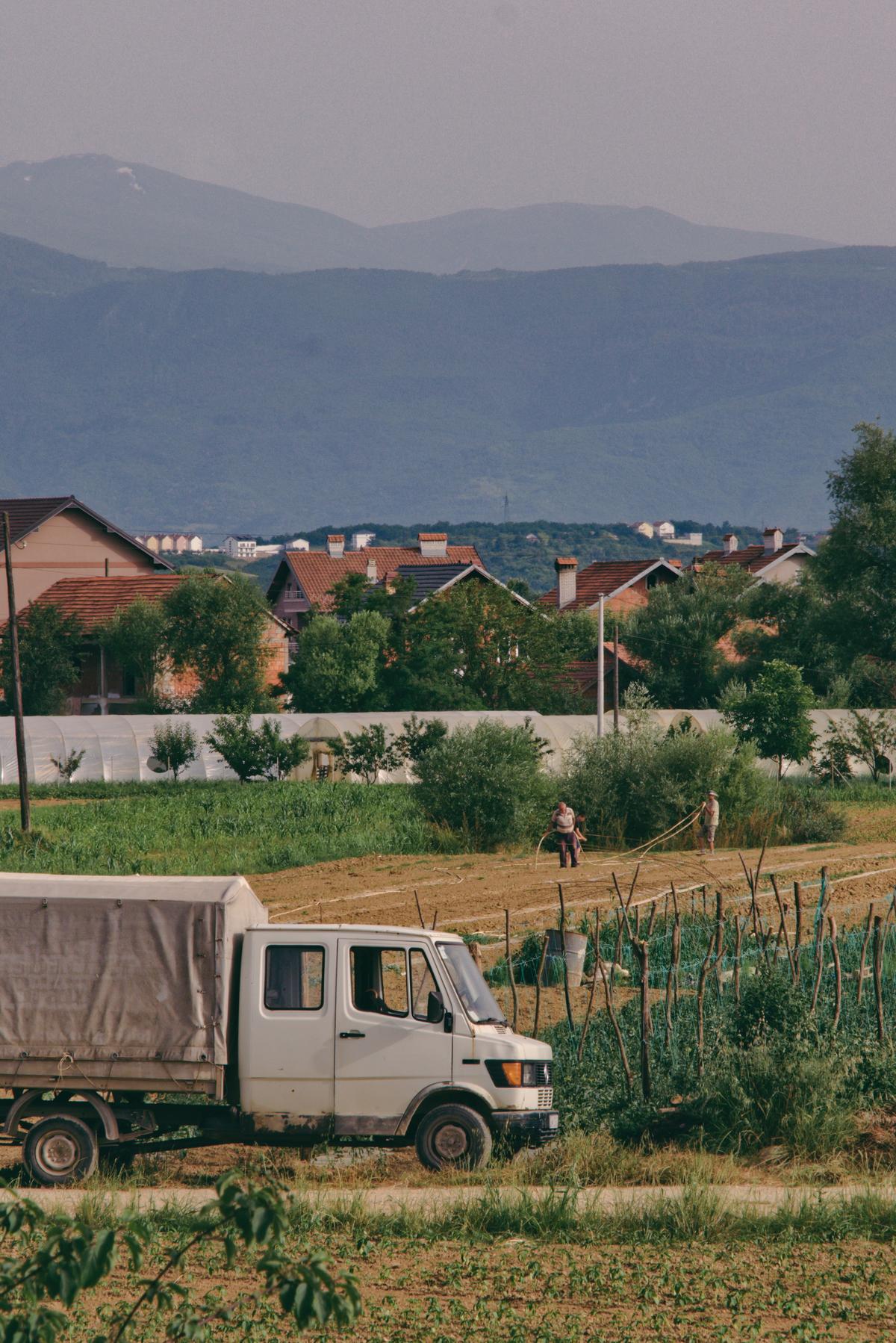 Three men lay hoses for crop irrigation in the evening between Gjakove and Prizren, Kosovo.