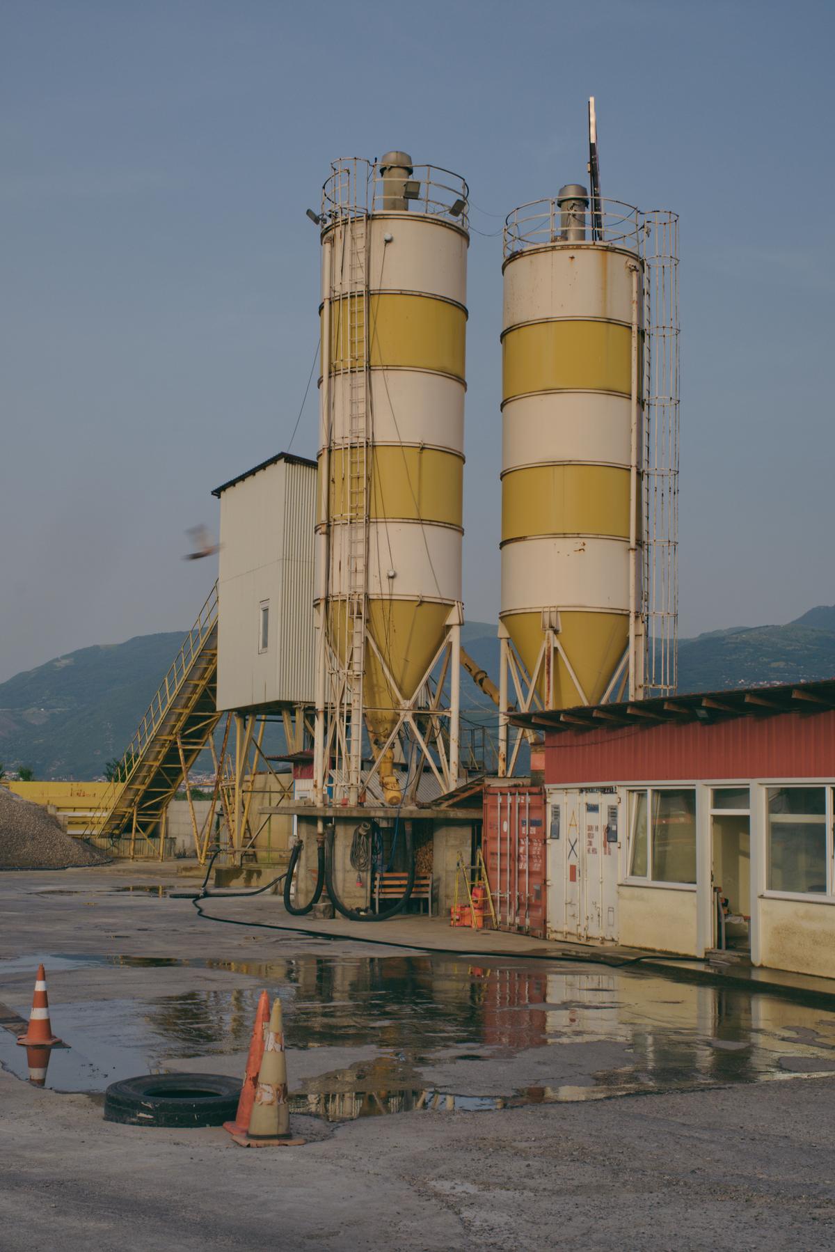 Two silos stand amidst a quiet industrial lot on the outskirts of Prizren, Kosovo