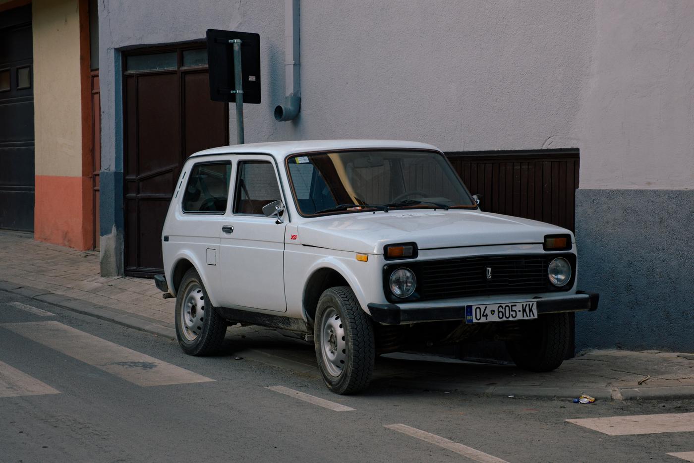 A pristine Lada Niva (the most beautiful car in the world) parked on the curb down a back street in Prizren, Kosovo.