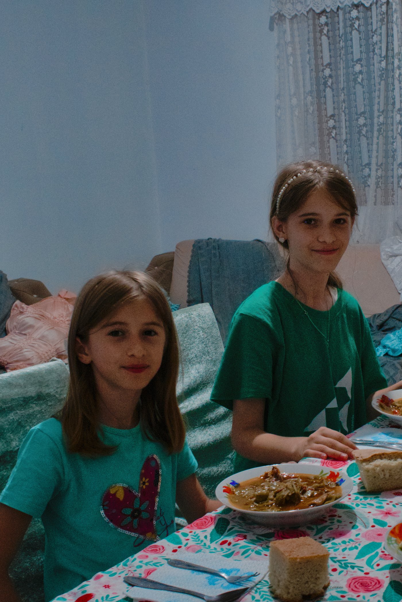 Feri and Xhoi smiling at the dinner table in their home in Labrazhd, Albania