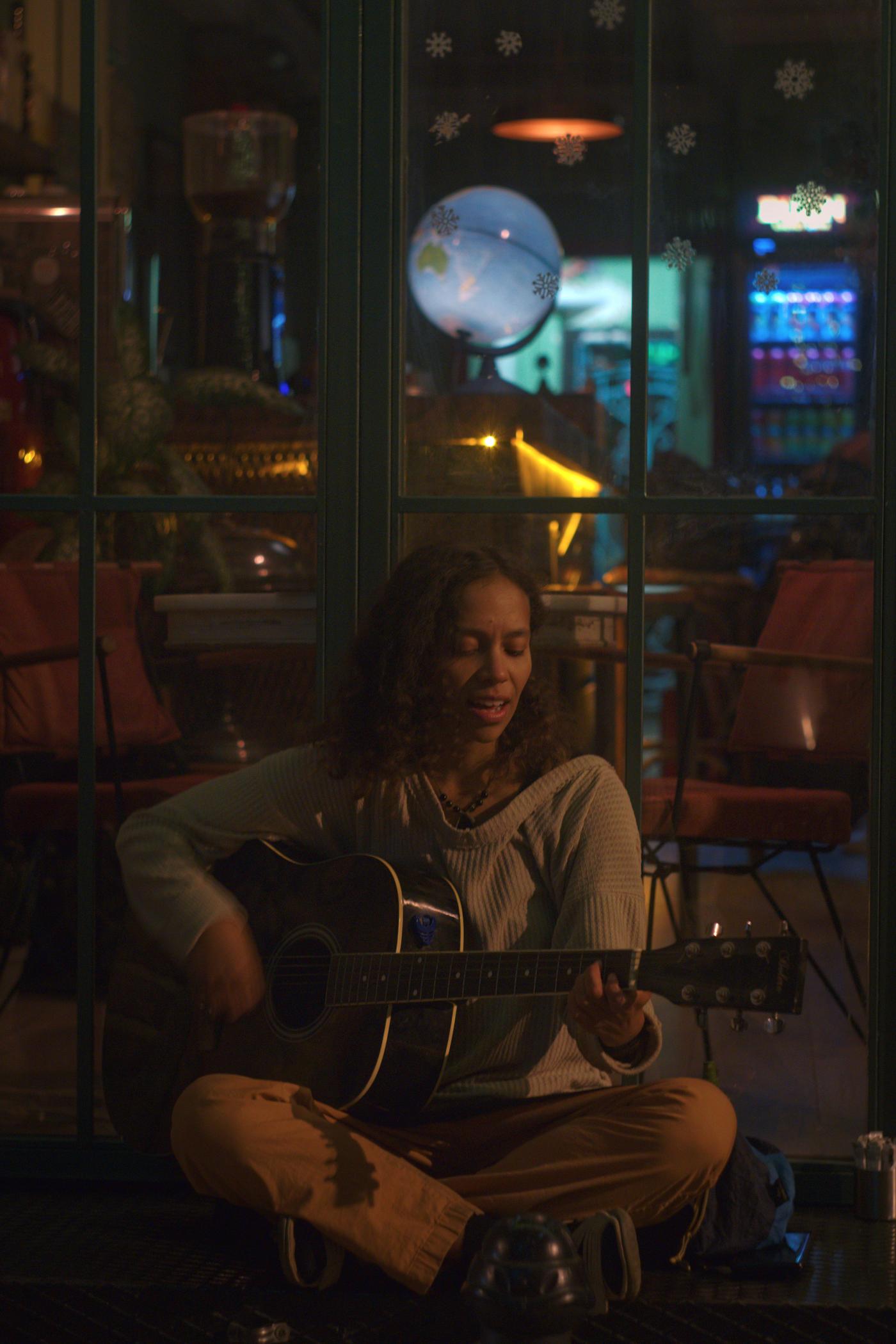 Jess sitting outside a hostel in Kadıköy, playing guitar and singing for me on our last night together in Istanbul