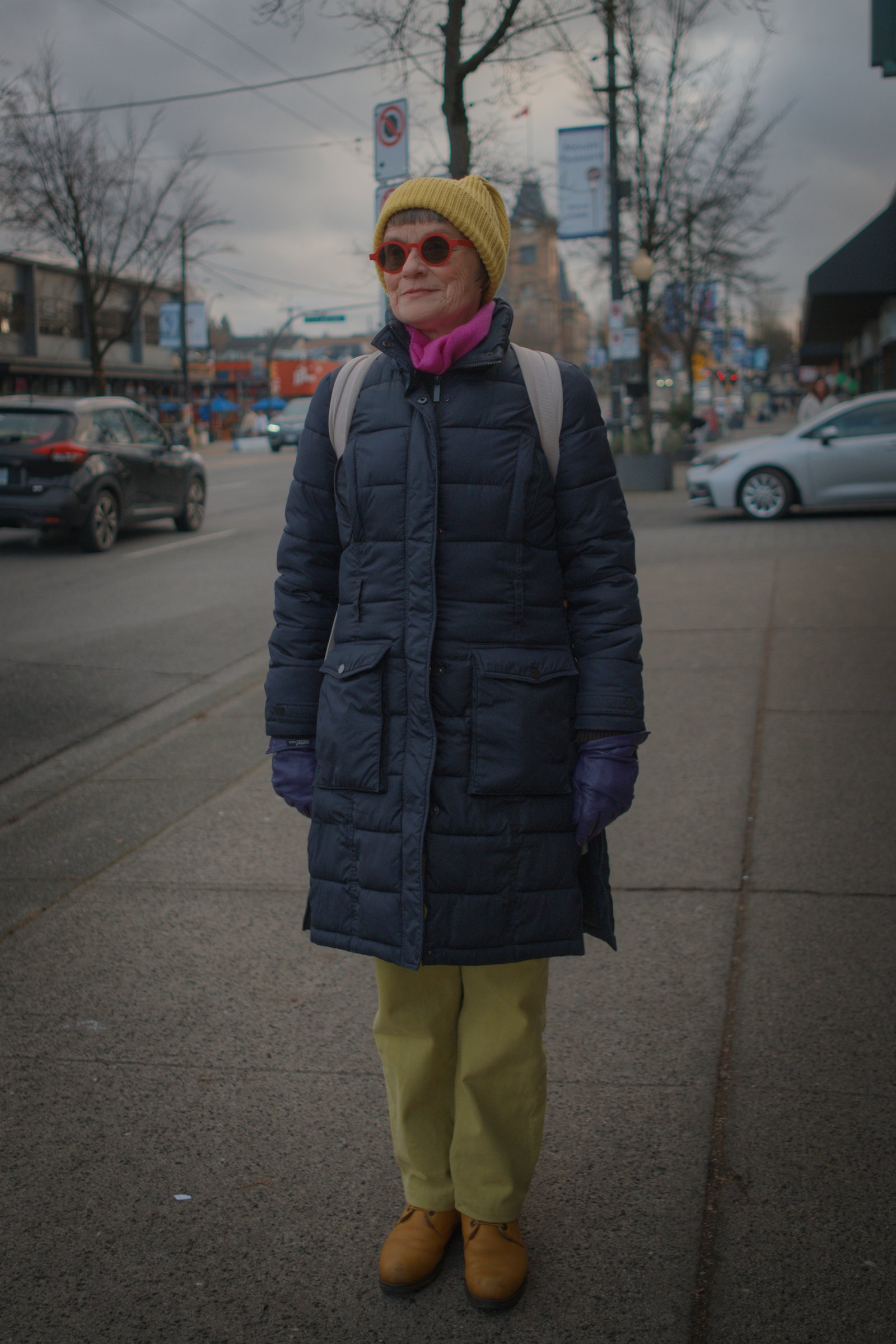 Claire, met on Main St, wearing bright yellow trousers and matching shoes and beanie. Vancouver, Canada