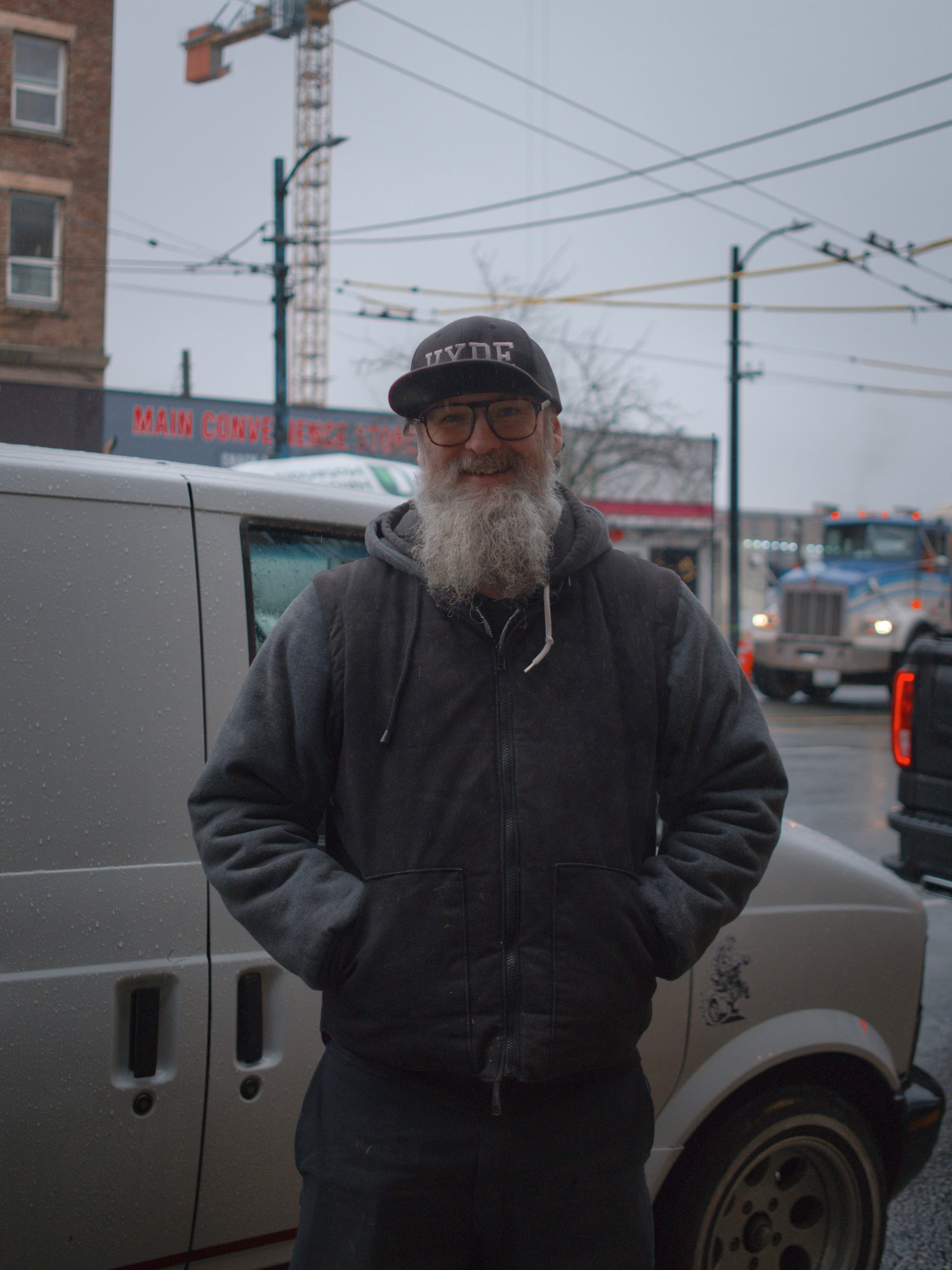 Neil standing in front of his custom van on Main St. Vancouver, Canada