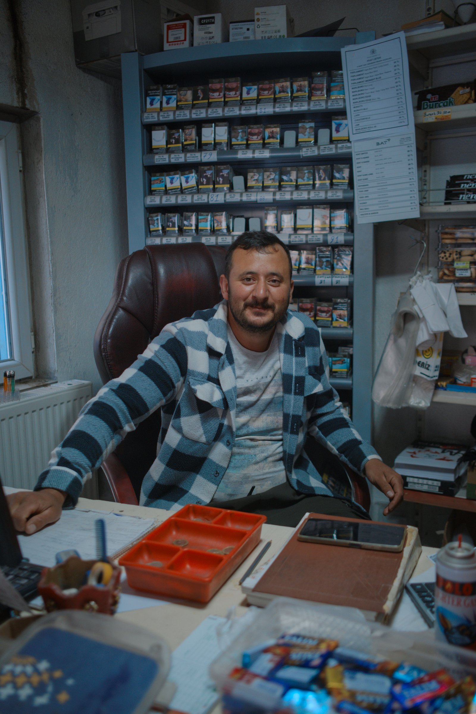 OÄźuz sitting in the well worn office chair from which he runs his tiny shop in the village of Agirnas, Turkey