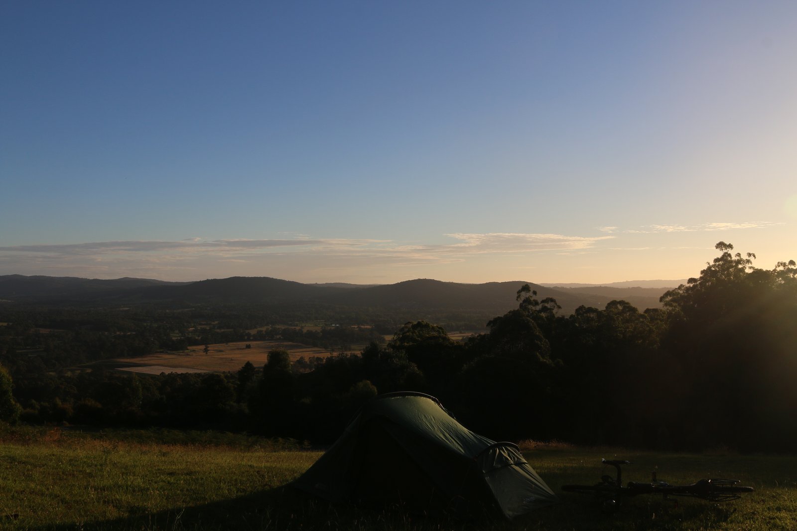 My tent, pitched on a hill looking across the valley as the sun sets. Victoria, Australia