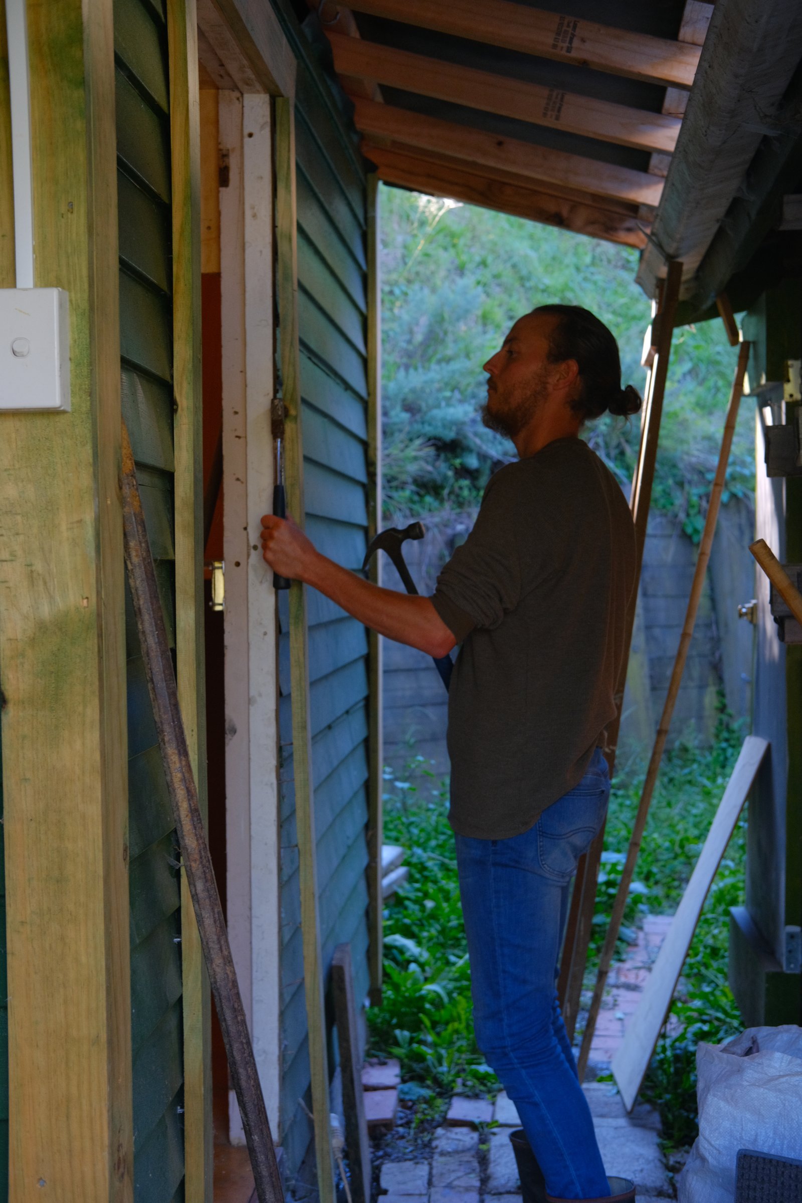 Prying the facade off Neville's abominable door frame.