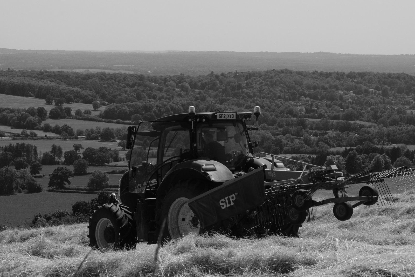 A farmer sits eating his lunch in his tractor