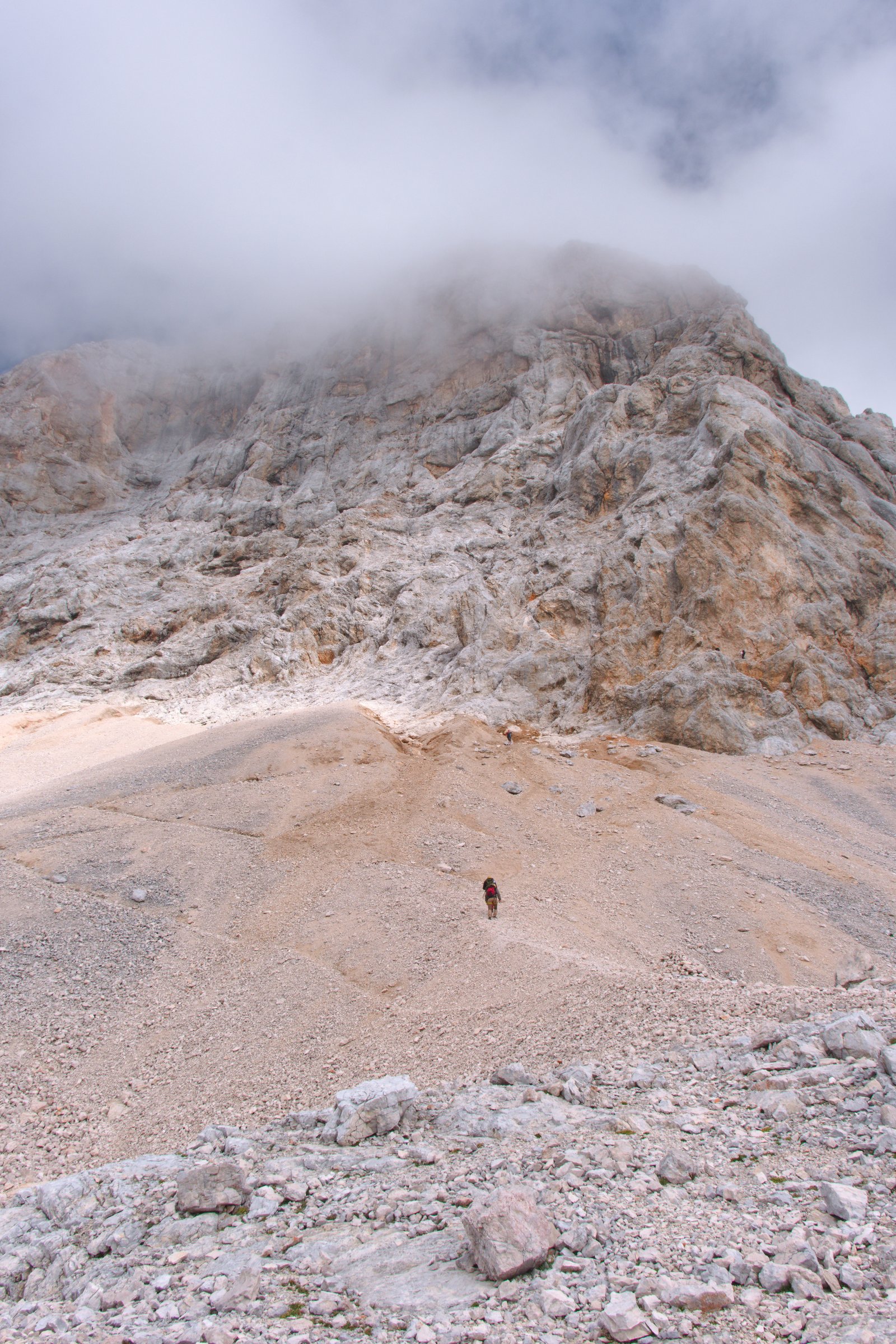 Two hikers head up the scree toward the steep face of Triglav. Slovenia