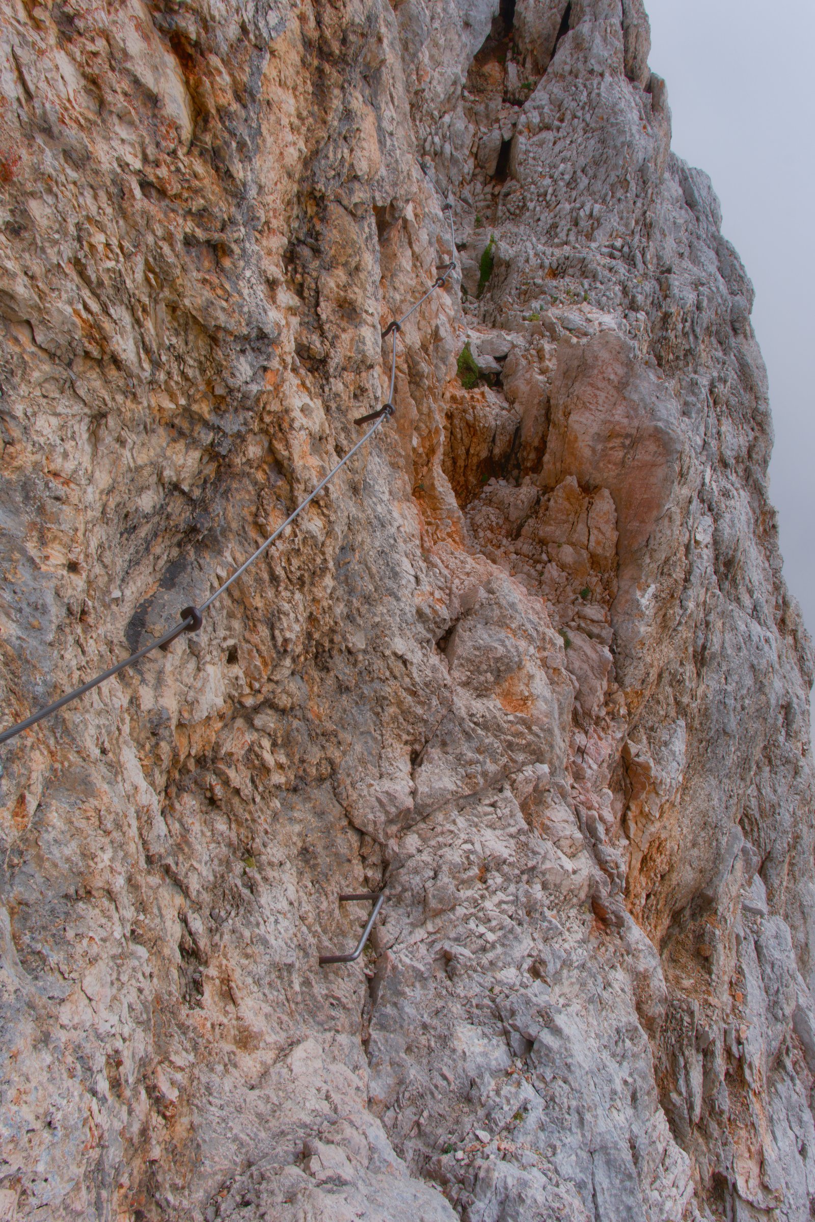 A small lip above a sheer drop. A cable spans to a 'less exposed' section on the far side. Triglav, Slovenia
