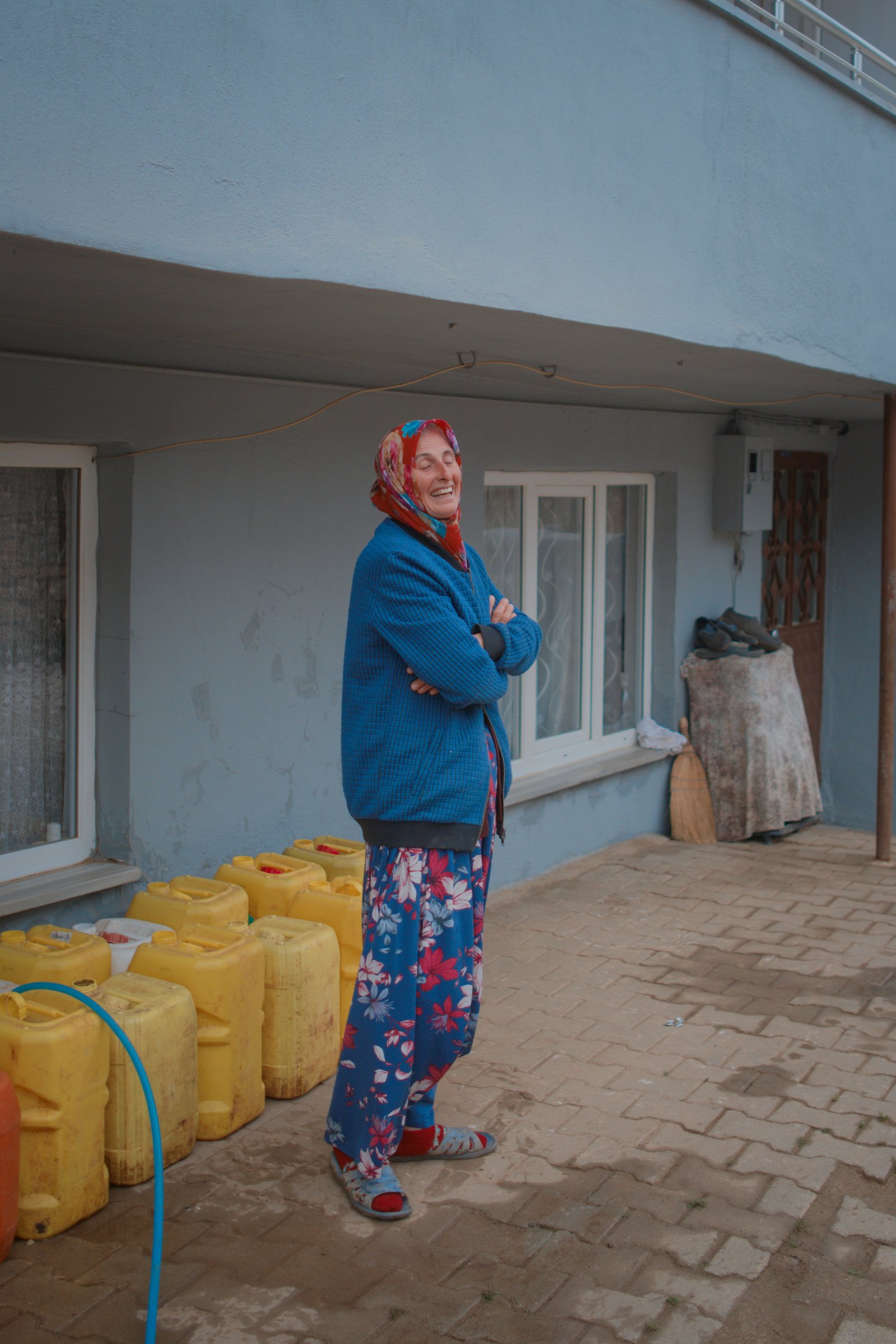 A woman laughs and closes her eyes after agreeing to have her photo taken. Mahmudiye, western Turkey