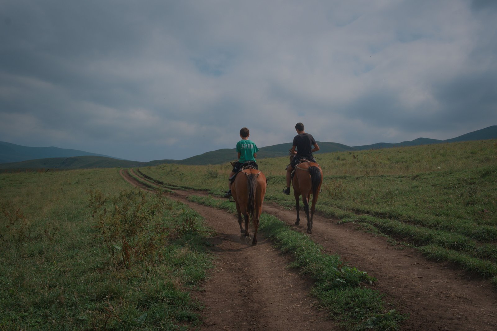 Two boys ride past us on their horses. Armenia