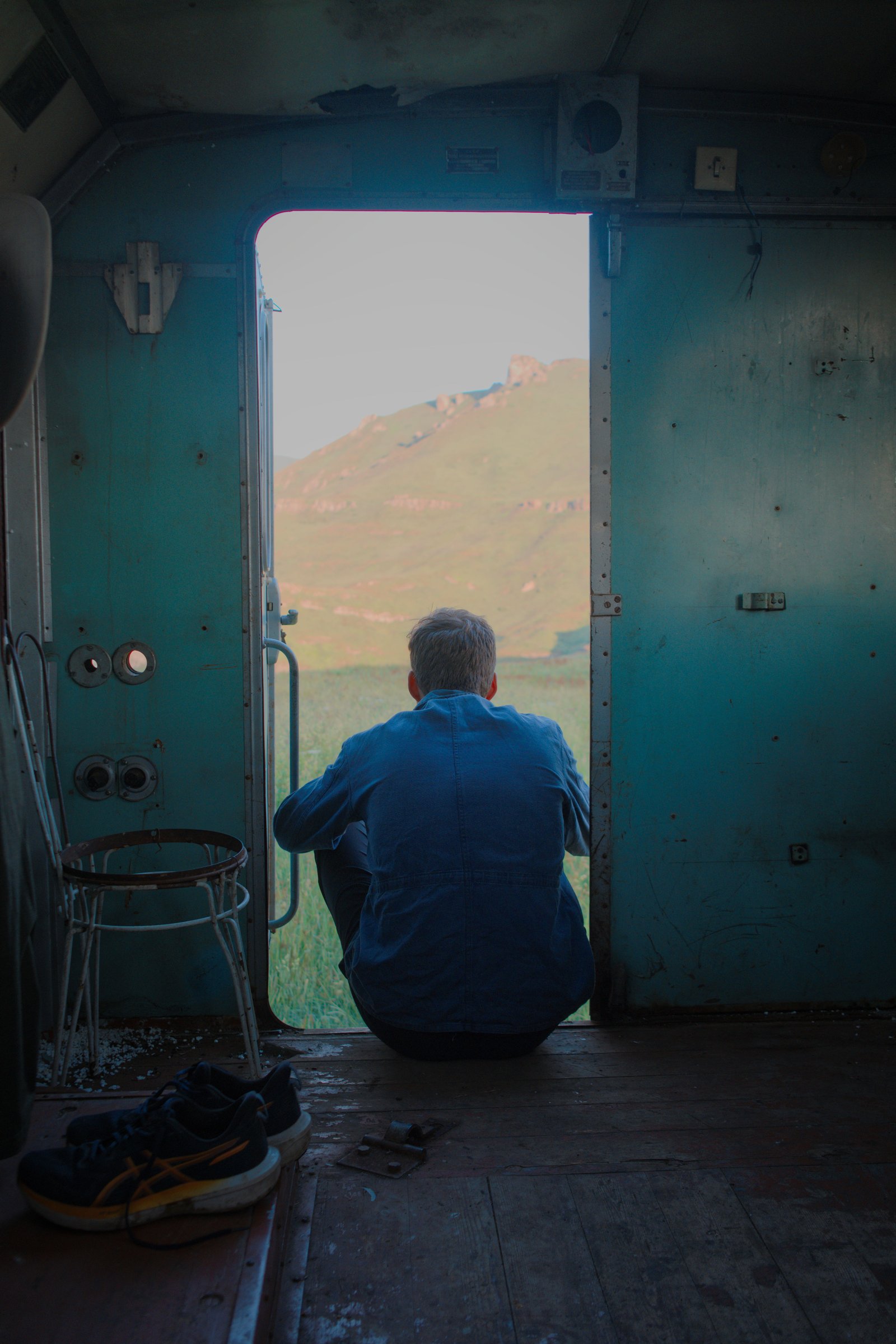 Jonny sits on the front step of our impromptu shelter for the night, sipping a coffee. Armenia