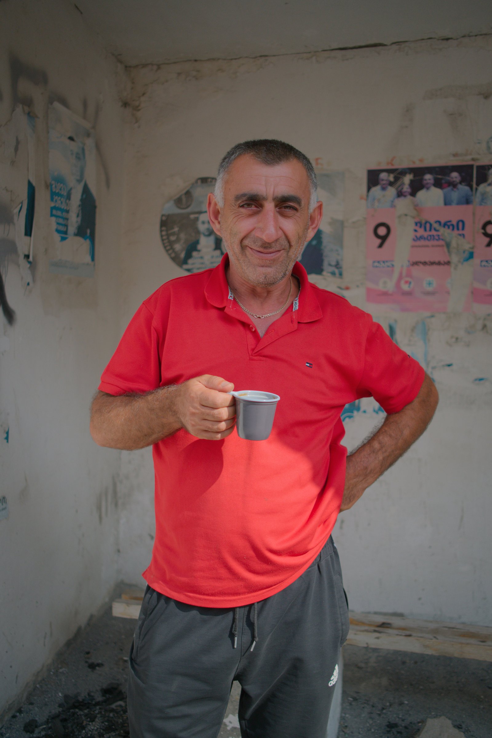 Vagram, an Armenian truck driver standing in the shade, drinking a coffee, patiently waiting a week and counting to pass customs at the Georgia/Russia border.