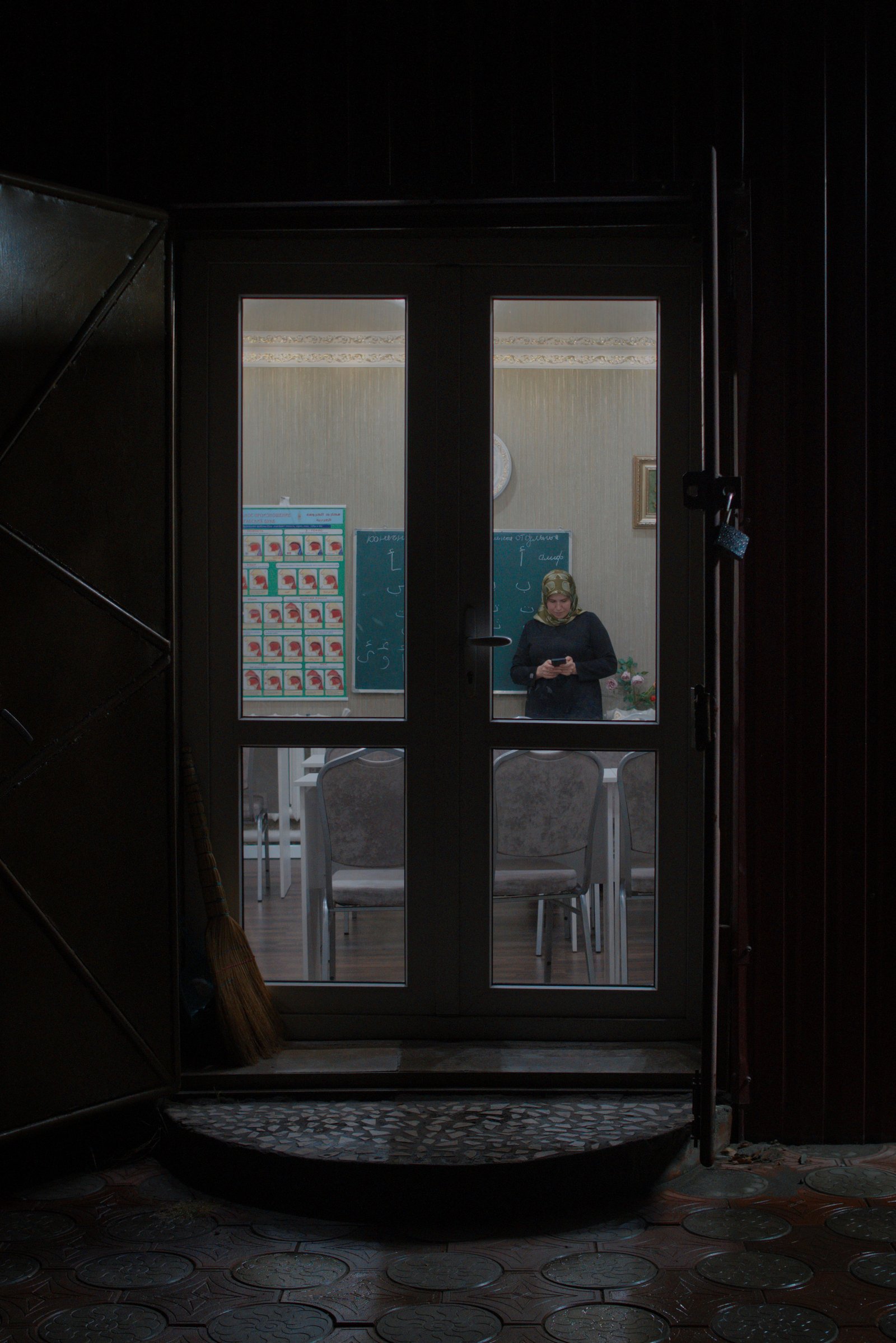 A teacher waits for her students to arrive at a community night-school in the village of Плиево (Plievo) in the Republic of Ingushetia, Russia