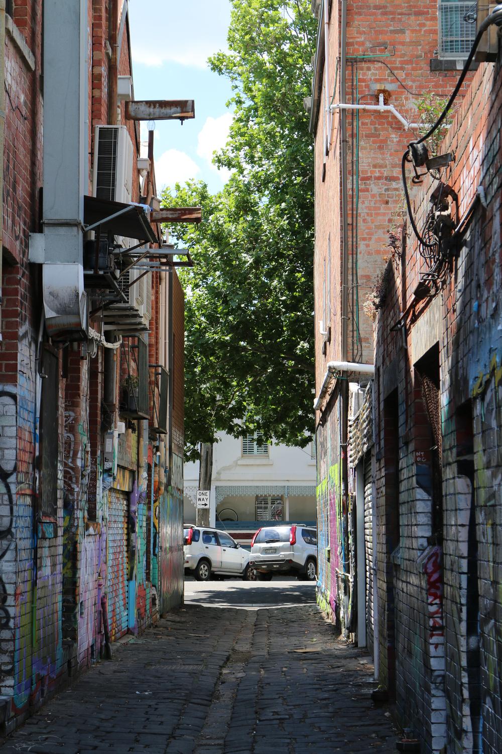 A grafitied alleyway between brick buildings in Fitzroy