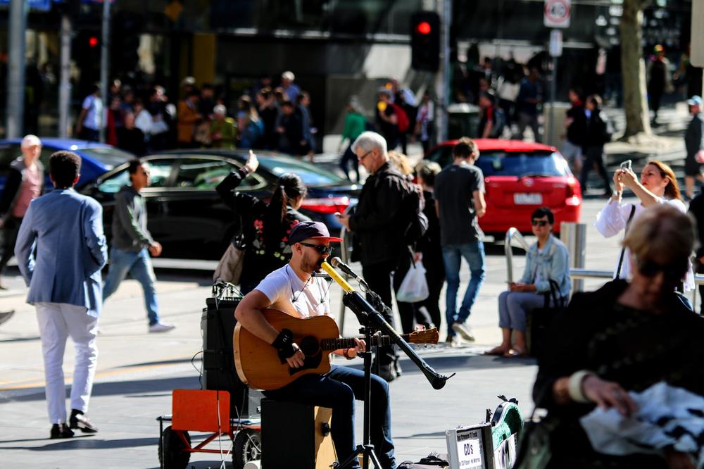 A musician plays guitar and sings in Melbourne CBD